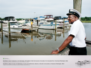 Bob Martin, former commodore of the Washington, DC Seafarers Yacht Club, is dressed in his Seafarers uniform, overlooking boats docked at the Yacht Club, on an overcast day.