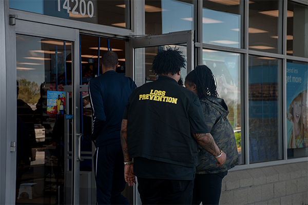 Alex Godfrey assists two customers into the Ross Dress for Less discount clothing store at the Laurel Lakes Shopping Centre. “Loss Prevention” is visible on the back of Godfrey’s shirt. 