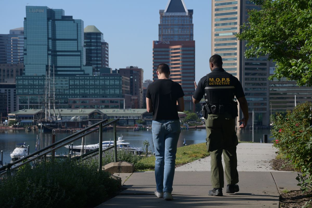 CNS reporter Rachel McCrea walks with private security officer Brian Askew at Federal Hill Park